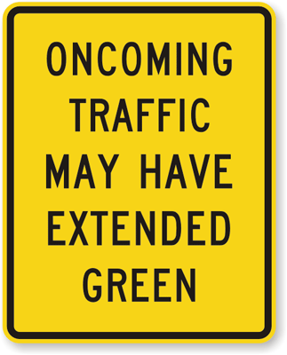 Oncoming traffic may have extended green sign