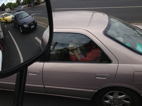 Child in car being held outside of seat